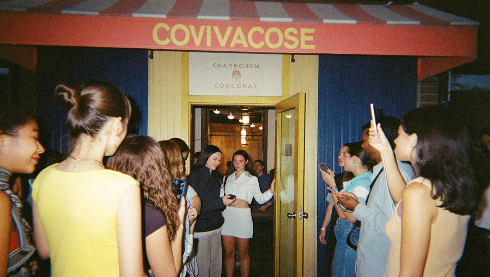 A creator greeting a line of attendees at the door of a small venue event