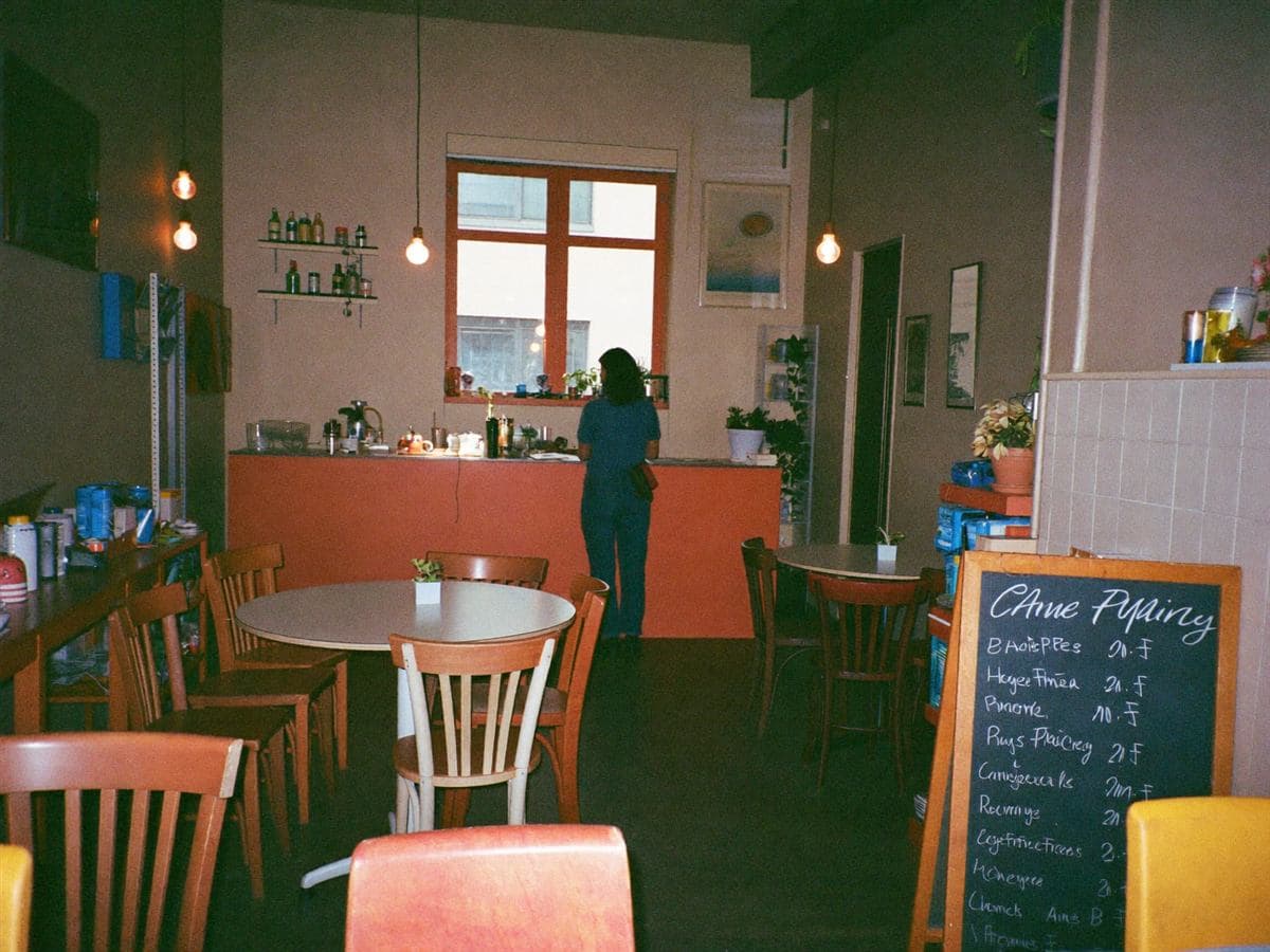 A quiet independent café interior on a slow weekday, owner behind the counter