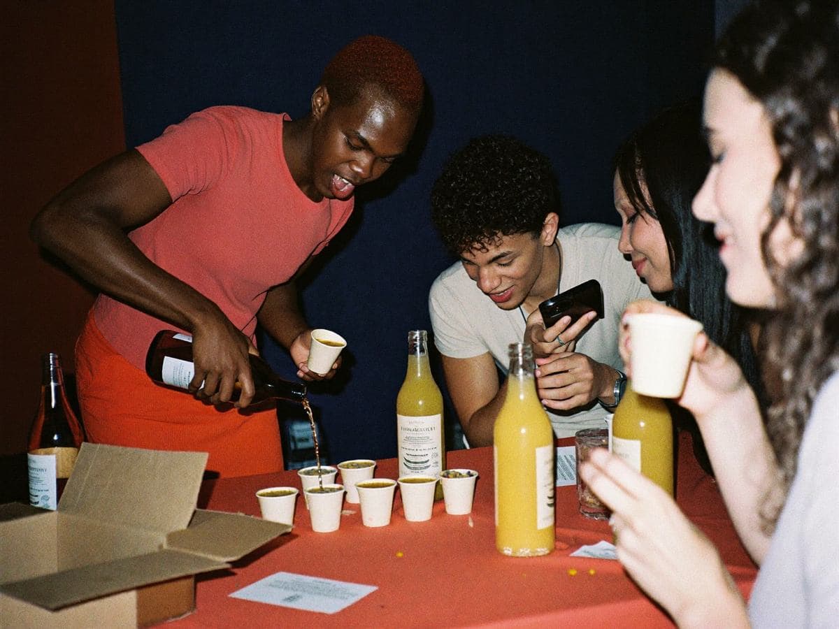 A local brand founder pouring product samples for attendees at an event table